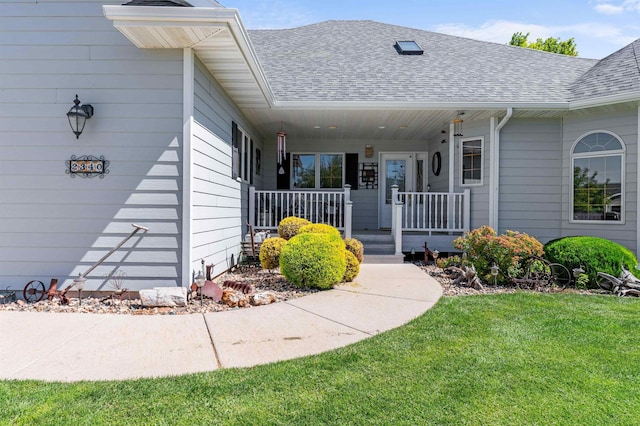 2340 Camaro Cir, Sturgis, SD 57785 - view of exterior entry featuring a porch, a shingled roof, and a yard