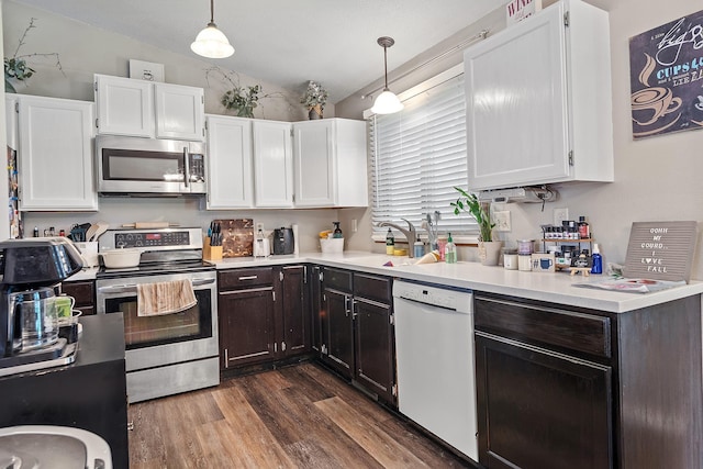 3111 Dry Creek Rd, Rapid City, SD 57703 - kitchen with appliances with stainless steel finishes, vaulted ceiling, a sink, white cabinetry, and dark wood finished floors