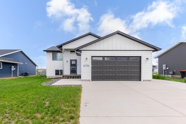 6794 Abelia St, Rapid City, SD 57703 - view of front facade featuring an attached garage, a front yard, driveway, and cooling unit