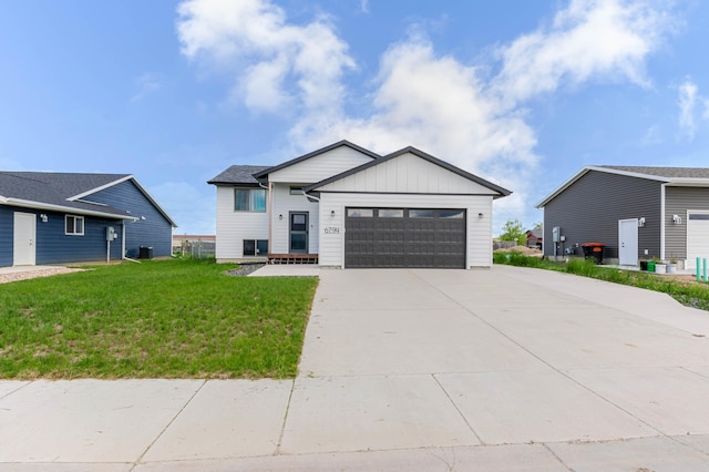6794 Abelia St, Rapid City, SD 57703 - view of front of property with a garage, driveway, board and batten siding, a front yard, and central AC unit