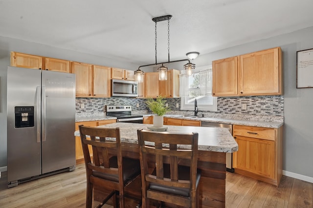 4425 Bronco Ln, Rapid City, SD 57701 - kitchen featuring appliances with stainless steel finishes, a sink, light wood finished floors, and tasteful backsplash