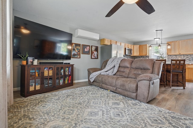 4425 Bronco Ln, Rapid City, SD 57701 - living room with a wall mounted air conditioner, ceiling fan, light wood-style floors, and baseboards