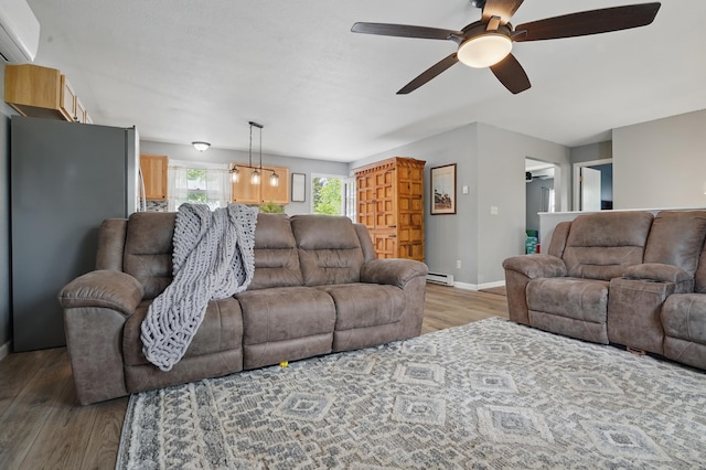 4425 Bronco Ln, Rapid City, SD 57701 - living area with a wall mounted AC, a ceiling fan, light wood finished floors, baseboard heating, and baseboards