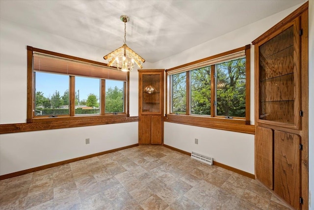 614 Englewood Ct, Spearfish, SD 57783 - spare room with a chandelier, baseboards, and stone finish floors