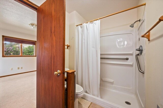 614 Englewood Ct, Spearfish, SD 57783 - full bathroom with a shower stall, a textured ceiling, toilet, and baseboards