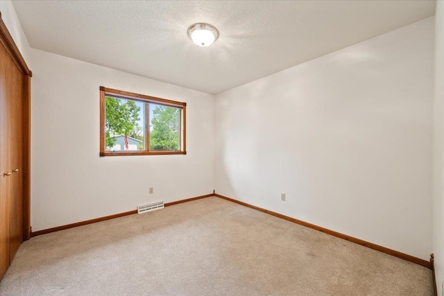 614 Englewood Ct, Spearfish, SD 57783 - unfurnished bedroom with light colored carpet, baseboards, a closet, and a textured ceiling