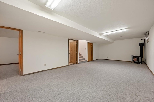 614 Englewood Ct, Spearfish, SD 57783 - finished below grade area featuring a wood stove, light colored carpet, stairway, and baseboards