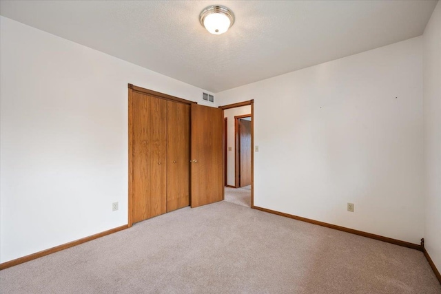 614 Englewood Ct, Spearfish, SD 57783 - unfurnished bedroom with light colored carpet, a closet, baseboards, and a textured ceiling