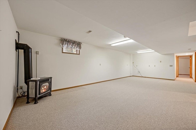 614 Englewood Ct, Spearfish, SD 57783 - finished basement featuring light colored carpet, a wood stove, and baseboards