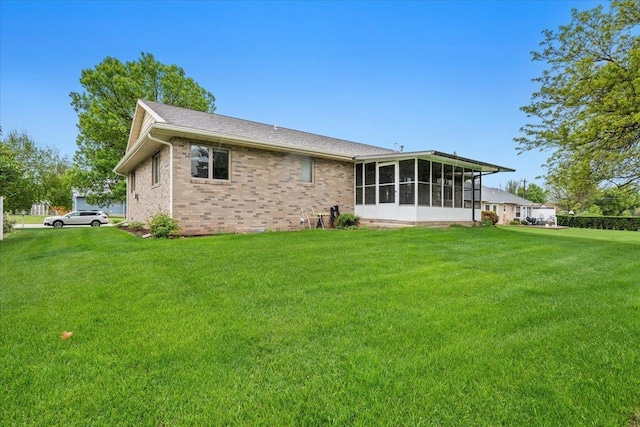 614 Englewood Ct, Spearfish, SD 57783 - back of house with a sunroom, a yard, and brick siding