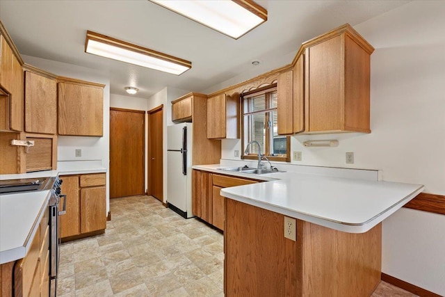 614 Englewood Ct, Spearfish, SD 57783 - kitchen featuring freestanding refrigerator, a sink, a peninsula, stainless steel stove, and light countertops
