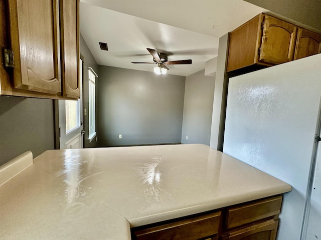 13B Statesboro Dr, Belle Fourche, SD 57717 - kitchen featuring a ceiling fan, brown cabinets, and light countertops