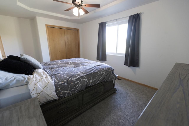 752 Bear Tooth Ct, Box Elder, SD 57719 - carpeted bedroom featuring a tray ceiling, a closet, baseboards, and ceiling fan