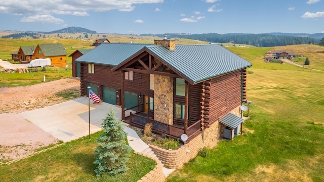 23470 Mineral Ln, Hill City, SD 57745 - log cabin featuring log siding, a chimney, driveway, a garage, and a standing seam roof
