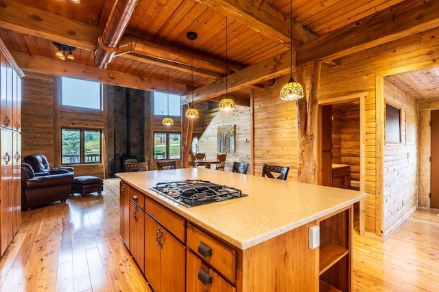 23470 Mineral Ln, Hill City, SD 57745 - kitchen with black gas stovetop, wooden ceiling with exposed beams, open floor plan, light wood-style floors, and wood walls