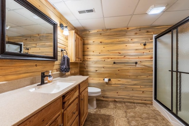 23470 Mineral Ln, Hill City, SD 57745 - full bath with a paneled ceiling, vanity, wood walls, toilet, and a stall shower