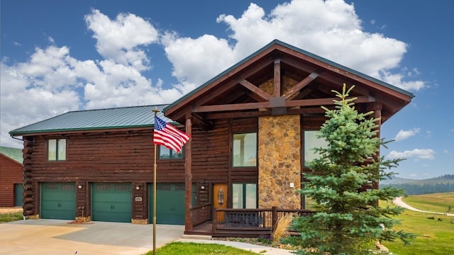 23470 Mineral Ln, Hill City, SD 57745 - log cabin featuring a garage, concrete driveway, log exterior, and metal roof