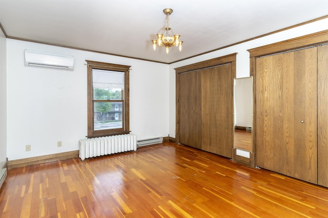 835 Harding St, Belle Fourche, SD 57717 - unfurnished bedroom featuring radiator, a wall unit AC, a baseboard radiator, a chandelier, and wood finished floors