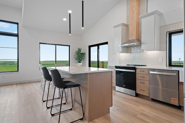 13439 Frontier Loop, Piedmont, SD 57769 - kitchen featuring dishwasher, electric range oven, high vaulted ceiling, a kitchen island, and light countertops
