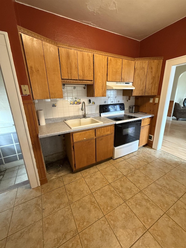 304 6th Ave, Edgemont, SD 57735 - kitchen with range with electric cooktop, a sink, under cabinet range hood, light countertops, and brown cabinetry