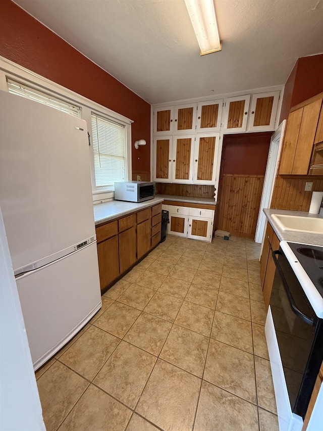 304 6th Ave, Edgemont, SD 57735 - kitchen featuring black range, freestanding refrigerator, stainless steel microwave, a sink, and light countertops