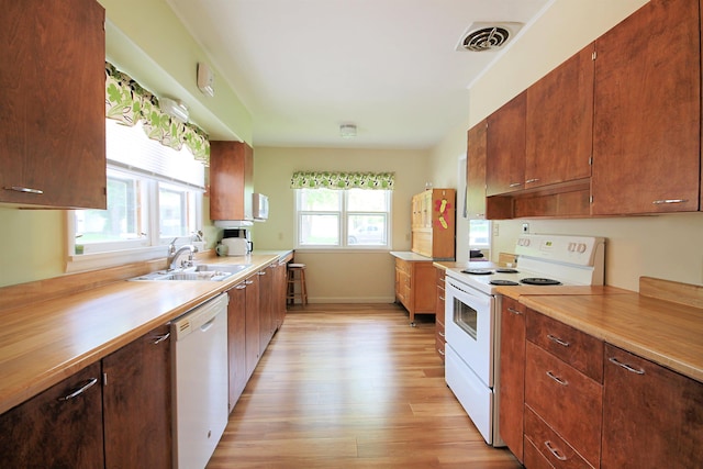 1033 Boulevard St, Sturgis, SD 57785 - kitchen with white appliances, a sink, light wood-style floors, light countertops, and baseboards