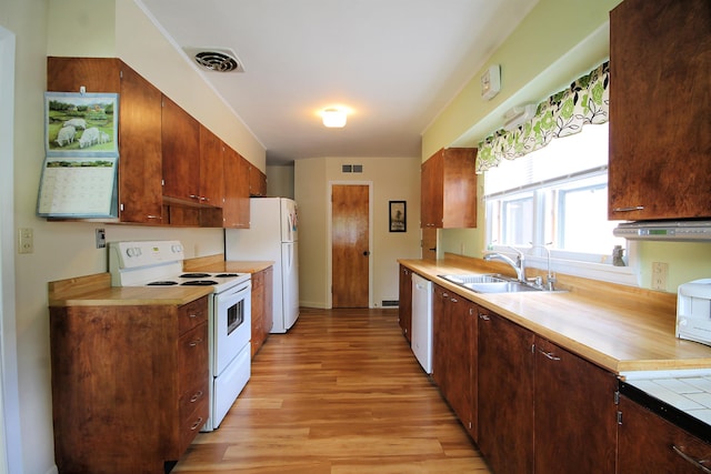1033 Boulevard St, Sturgis, SD 57785 - kitchen with white appliances, a sink, light wood-type flooring, light countertops, and exhaust hood