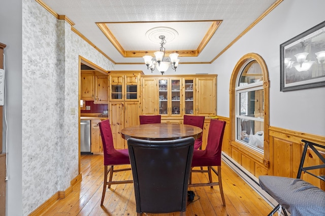 25370 S Lightning Creek Rd, Custer, SD 57730 - dining space featuring light wood finished floors, a chandelier, a tray ceiling, wainscoting, and crown molding