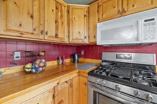 25370 S Lightning Creek Rd, Custer, SD 57730 - kitchen featuring white microwave, stainless steel range with gas stovetop, tasteful backsplash, and butcher block counters