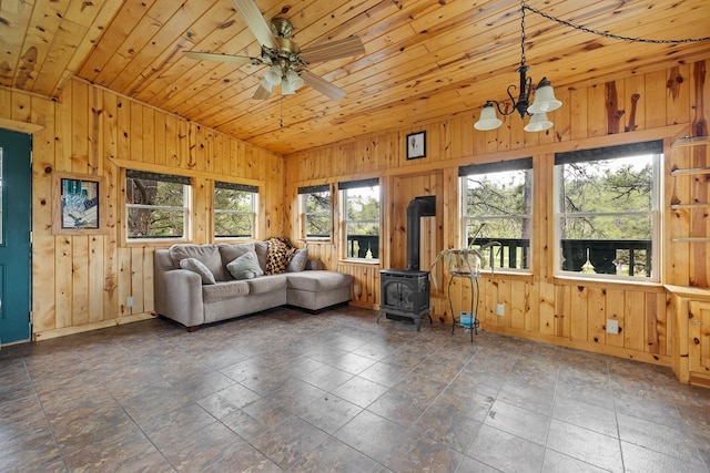 25370 S Lightning Creek Rd, Custer, SD 57730 - living room featuring a wood stove, wood walls, a chandelier, baseboards, and a ceiling fan