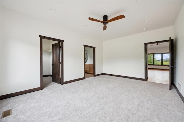 2431 Malibu Loop, Sturgis, SD 57785 - unfurnished bedroom with carpet flooring, a walk in closet, baseboards, a ceiling fan, and ensuite bathroom
