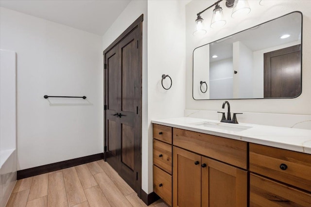 2431 Malibu Loop, Sturgis, SD 57785 - bathroom featuring vanity, wood finished floors, baseboards, and a bath
