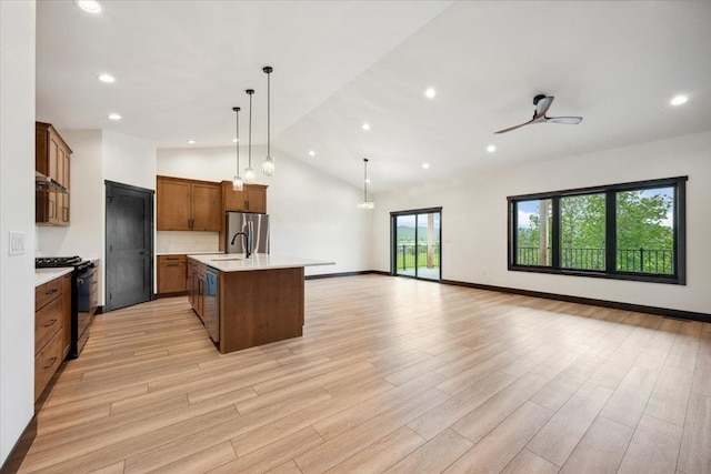 2431 Malibu Loop, Sturgis, SD 57785 - kitchen featuring appliances with stainless steel finishes, open floor plan, light countertops, vaulted ceiling, and light wood-type flooring