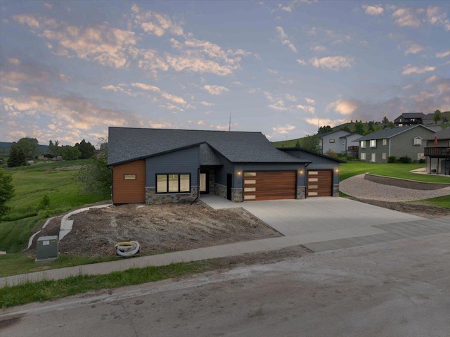 2431 Malibu Loop, Sturgis, SD 57785 - modern home with an attached garage, stone siding, concrete driveway, and a residential view
