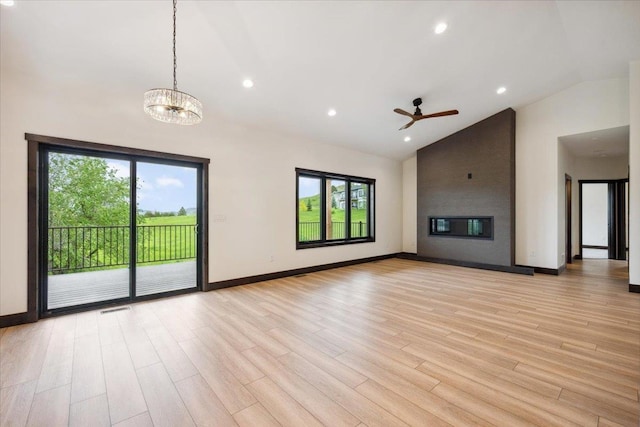 2431 Malibu Loop, Sturgis, SD 57785 - unfurnished living room with plenty of natural light, high vaulted ceiling, a fireplace, light wood-style floors, and ceiling fan