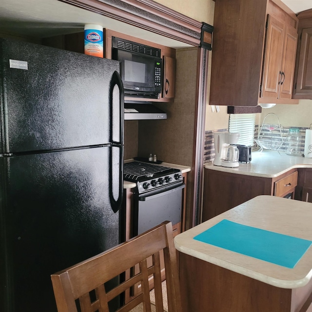 12748 Beaver Creek Rd, Custer, SD 57730 - kitchen with black appliances, light countertops, and under cabinet range hood
