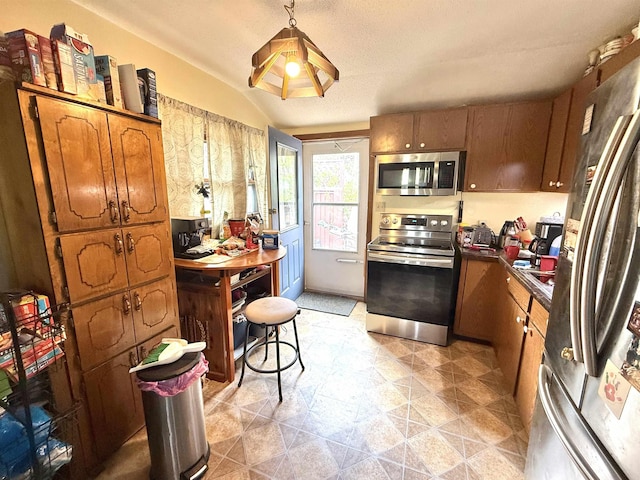 403 Mcquillan Ave, Lead, SD 57754 - kitchen featuring stainless steel appliances, brown cabinets, dark countertops, and lofted ceiling
