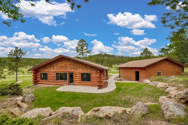 12162 Laramie Trl, Custer, SD 57730 - rear view of house with a patio, a yard, log siding, and a wooded view