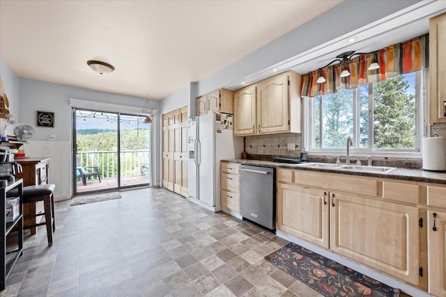 824 W Mcclellan St, Lead, SD 57754 - kitchen featuring light brown cabinets, stainless steel dishwasher, a sink, dark countertops, and white refrigerator with ice dispenser