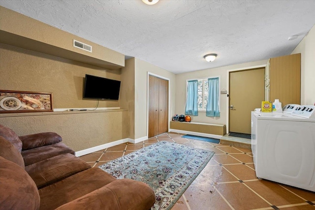 824 W Mcclellan St, Lead, SD 57754 - tiled living room featuring washing machine and clothes dryer, baseboards, a textured wall, and a textured ceiling