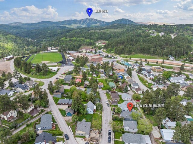 824 W Mcclellan St, Lead, SD 57754 - aerial view of property and surrounding area featuring mountains, a forest, and nearby suburban area
