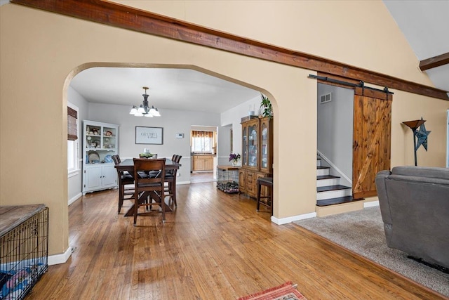 824 W Mcclellan St, Lead, SD 57754 - dining space with arched walkways, wood-type flooring, a chandelier, and baseboards