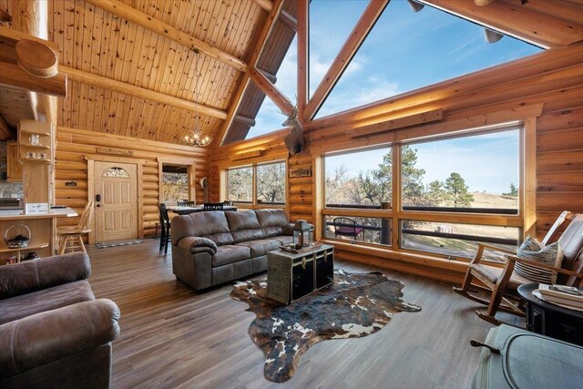 15377 Ridgeview Trl, Piedmont, SD 57783 - living room featuring log walls, high vaulted ceiling, wood finished floors, and wooden ceiling with exposed beams