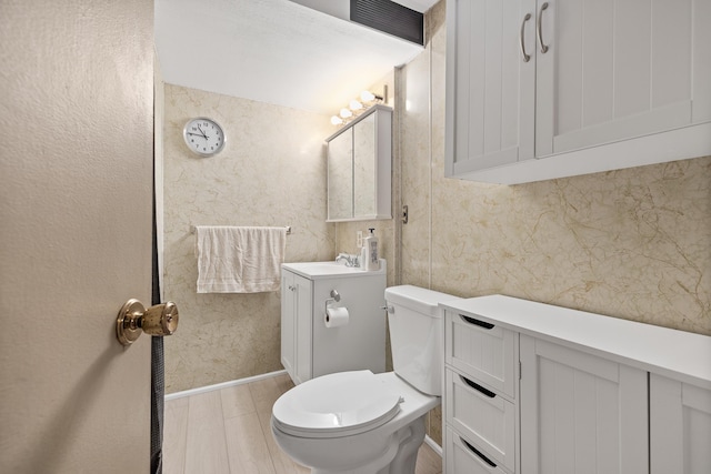 4902 Baldwin St, Rapid City, SD 57702 - half bath featuring vanity, toilet, and wood finished floors