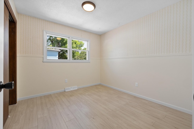 4902 Baldwin St, Rapid City, SD 57702 - spare room featuring light wood-type flooring, wallpapered walls, and baseboards