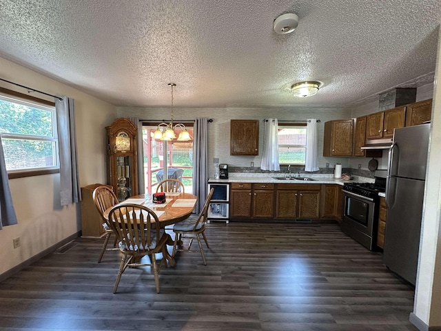 2407 Fox Rd, Sturgis, SD 57785 - kitchen with appliances with stainless steel finishes, under cabinet range hood, light countertops, dark wood-style floors, and a chandelier