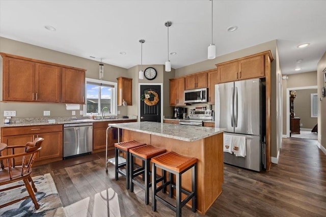 3781 W Beartooth Loop, Spearfish, SD 57783 - kitchen with appliances with stainless steel finishes, brown cabinets, dark wood-style flooring, a center island, and pendant lighting