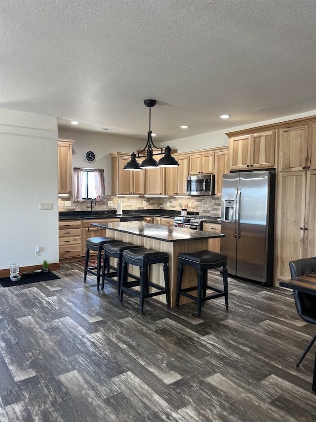 215 Meadowlark Dr, Hot Springs, SD 57747 - kitchen featuring stainless steel appliances, dark countertops, a center island, dark wood-type flooring, and a textured ceiling