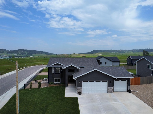 3408 Davenport Loop, Sturgis, SD 57785 - view of front facade with a garage, concrete driveway, stone siding, and a mountain view