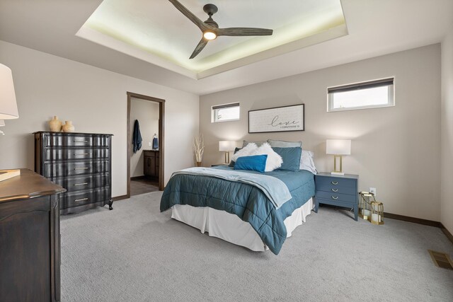 6315 Dunsmore Rd, Rapid City, SD 57702 - bedroom with a tray ceiling, light carpet, a ceiling fan, and ensuite bath